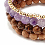 Ein Set aus vier Armbändern aus Amethyst, Rhodonit, Holzperlen und Metall