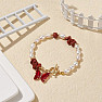 Weißes Perlenarmband mit rotem Jaspis und Schmetterling