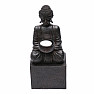Buddha sitzt auf einem Sockel mit einer schwarzen Statuette mit Kerzenständer