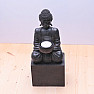 Buddha sitzt auf einem Sockel mit einer schwarzen Statuette mit Kerzenständer