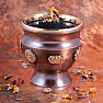 Eine braune Metallschale in Form einer Tasse mit Chakra-Symbolen