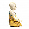 Statuette eines buddhistischen Mönchs eines Jungen in einem gelben Gewand gefärbt